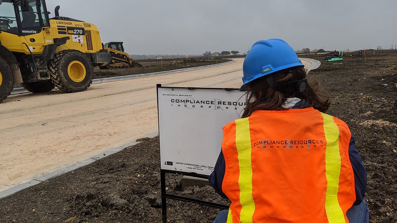 Inspector providing stormwater training; a female inspector on a residential construction site.